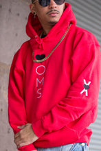 Load image into Gallery viewer, Man wearing red hoodie with heart-oms logo vertically embroidered down the front, and &quot;heart on my sleeve&quot; screenprinted down the righta arm.