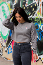 Load image into Gallery viewer, Woman wearing grey cotton crop sweatshirt with white HOMS logo and symbol in cursive on left chest